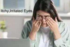 woman rubbing her eyes at her desk